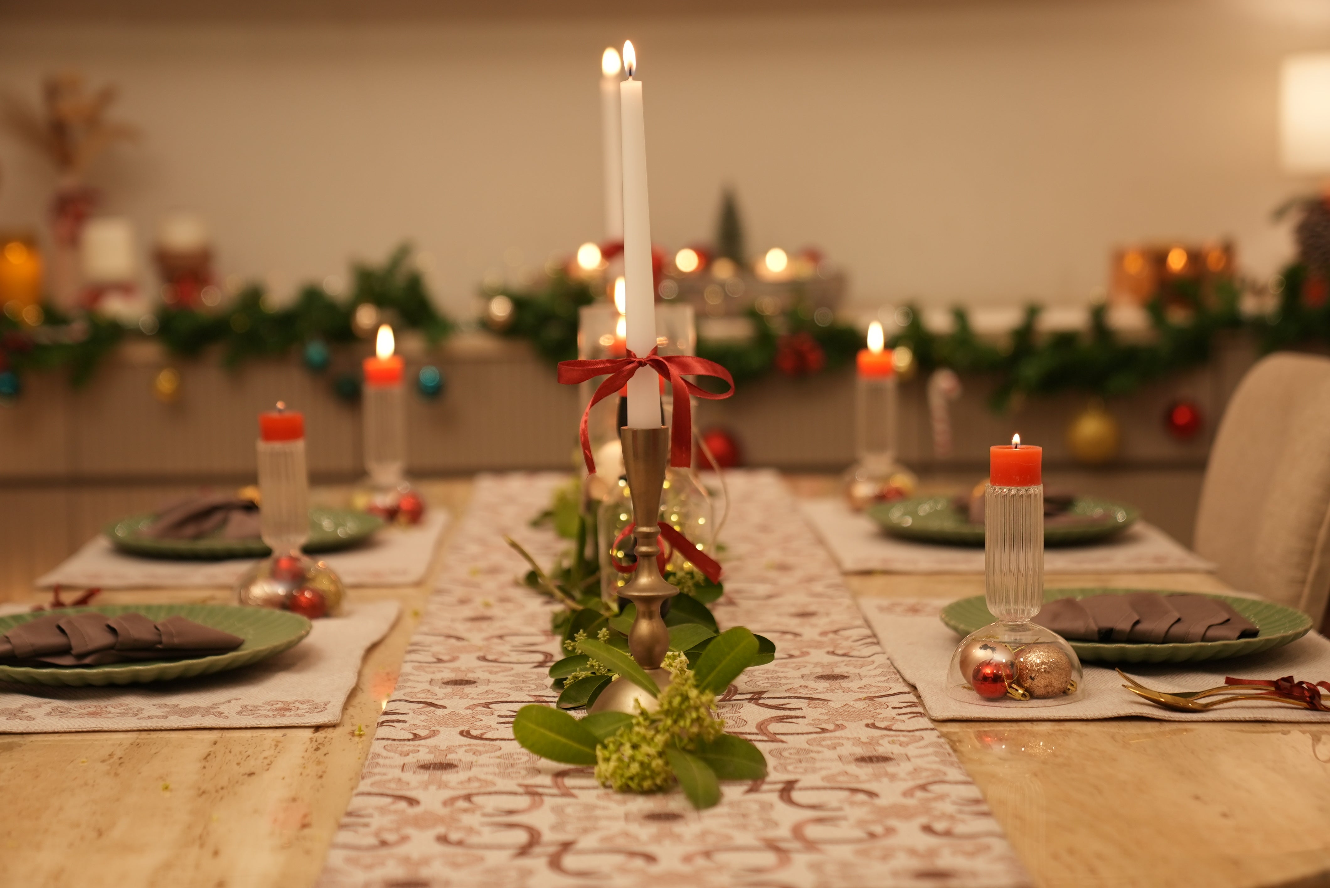 Decorative Christmas table setting with candles and greenery